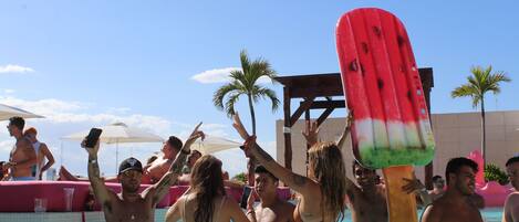 Alberca al aire libre, sombrillas en la alberca y camastros