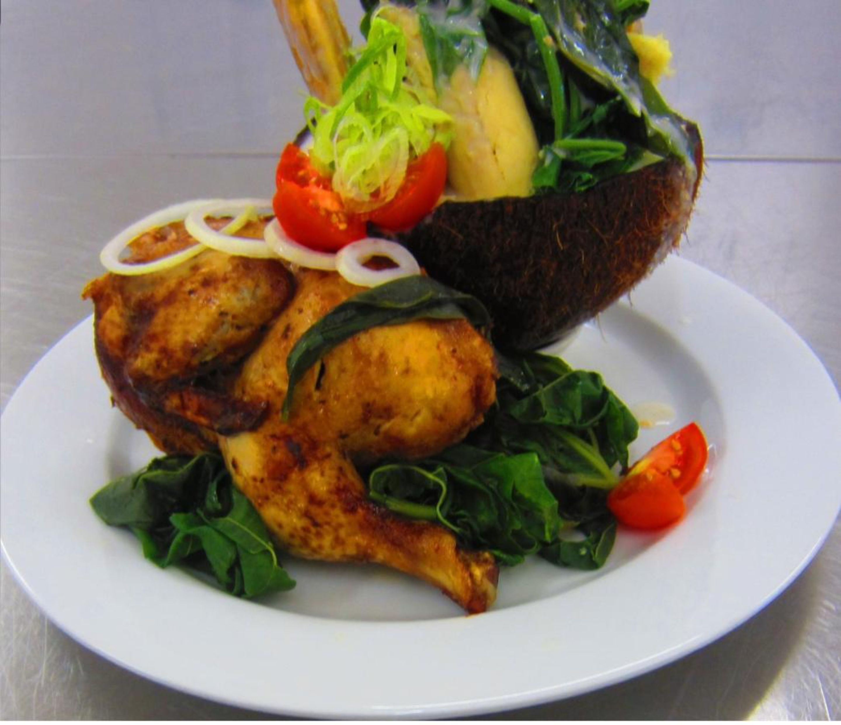 A plate with grilled chicken, a baked potato, and a side salad.