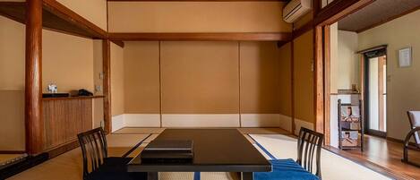Ein traditioneller japanischer Raum mit Tatami-Böden, einem niedrigen Tisch und Holzmöbeln.
