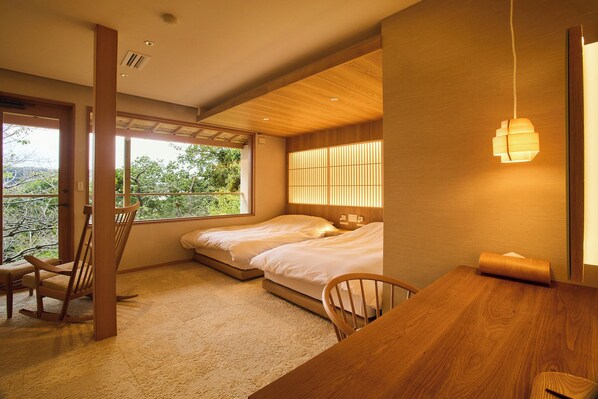 A bedroom with two beds, a wooden desk, and a chair.
