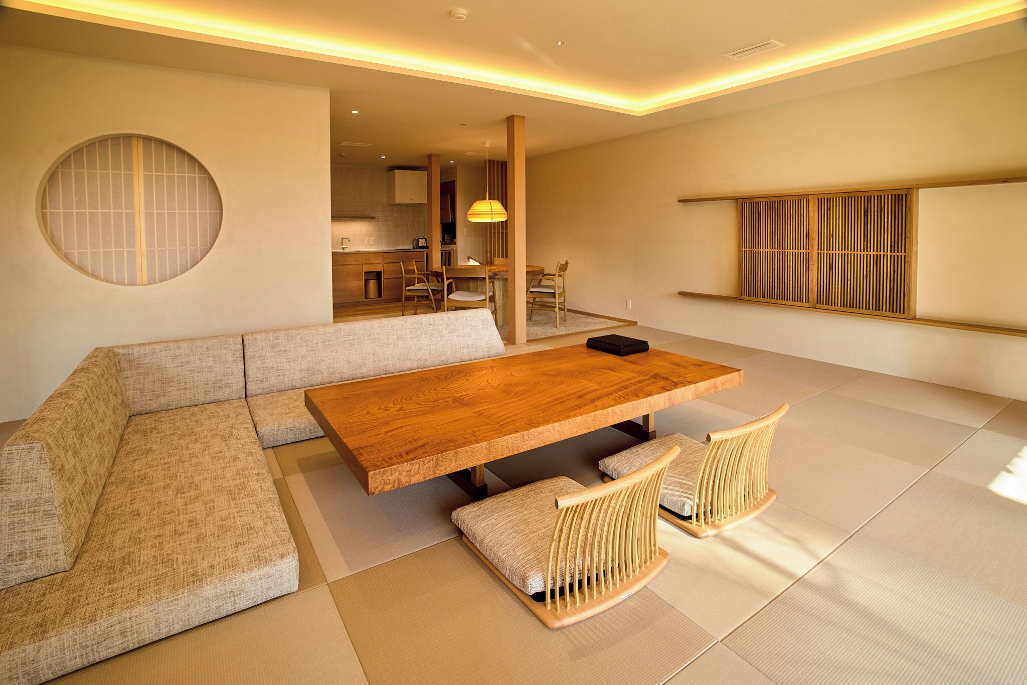 Una sala de estar moderna con una mesa de comedor de madera, sofás acolchados y suelo de tatami.