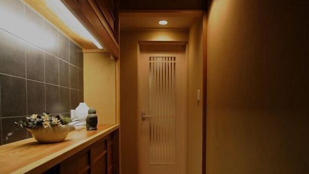 A narrow hallway with wooden flooring and a tiled wall on one side. - Gion Machiya (Kyoto)