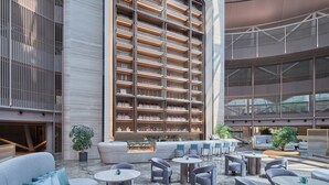 Un interior moderno con una zona de bar, asientos y un amplio estante exhibiendo botellas.
