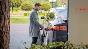 A person charging a Tesla car at a charging station. - Asteria Hotel Venray (Venray)