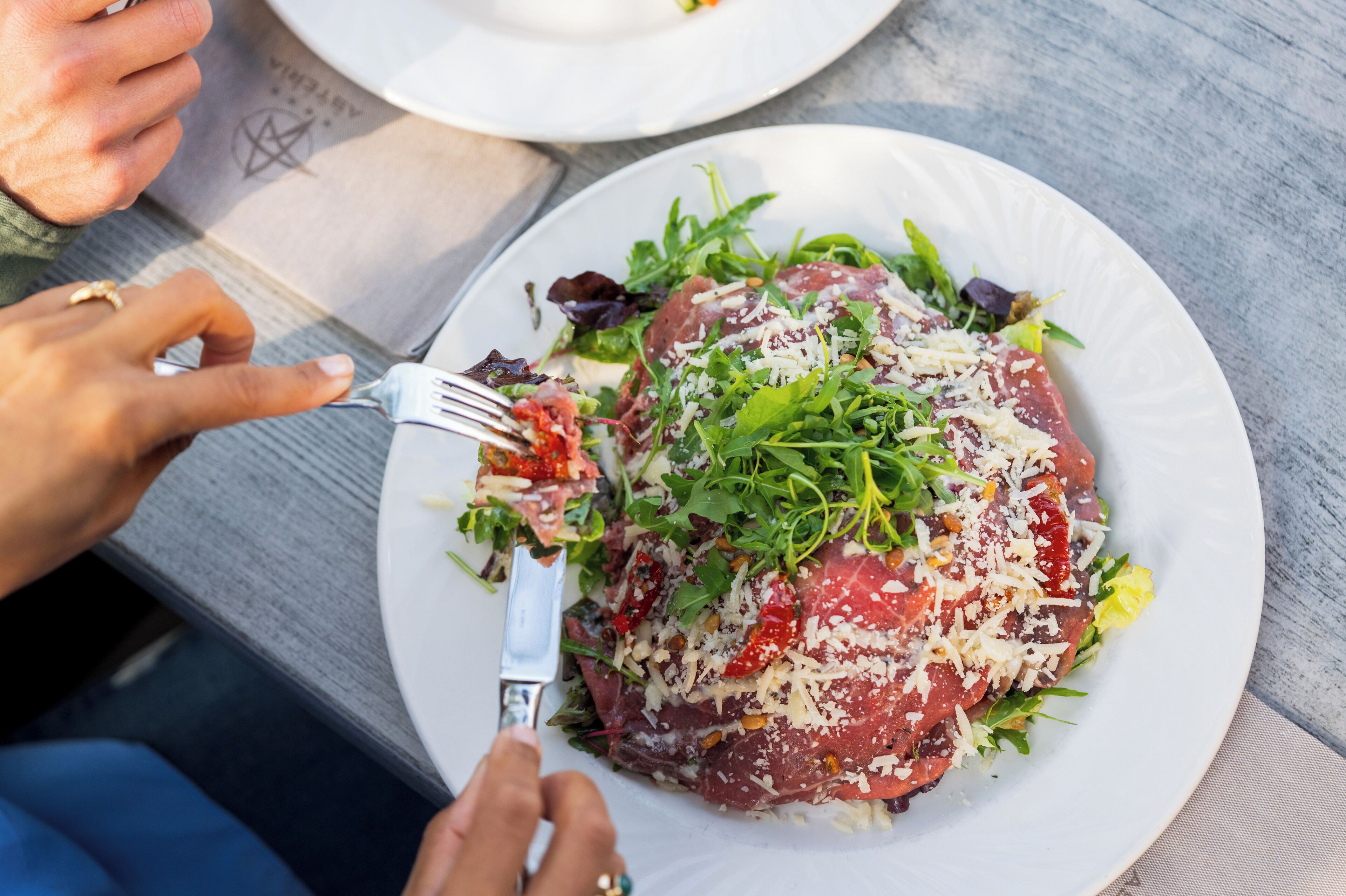 A plate of food with a fork and knife on a table.