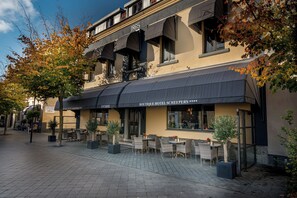 A boutique hotel with outdoor seating, a sign reading "1865", and a clear sky. - Boutique Hotel Scheepers (Valkenburg aan de Geul)