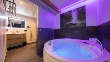 Relax in a spacious bathroom with a large oval-shaped bathtub and wall-mounted mirror.