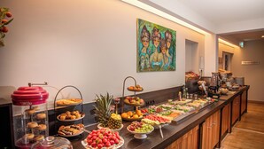 Un bufé con diversos alimentos y un cuadro en la pared.
