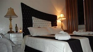 A hotel room with a large bed, two bedside tables, a nightstand, and a lamp. - Trastevere Relais (Rome)
