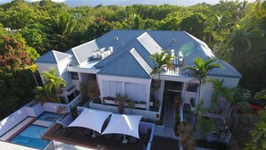 A modern house with a swimming pool, covered patio, and lush greenery. - Silkari The Pavilions Port Douglas (Port Douglas)
