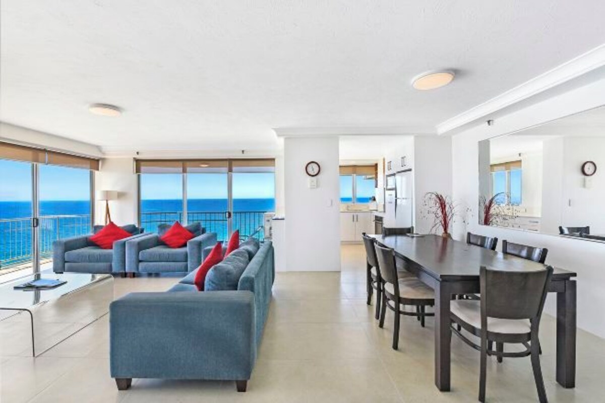 Una sala de estar moderna con un amplio sofá y una zona de comedor.