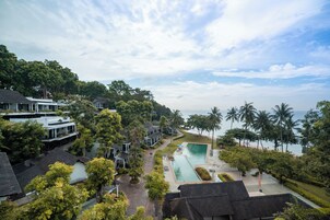 Un resort con piscina, palmeras y vista al océano.