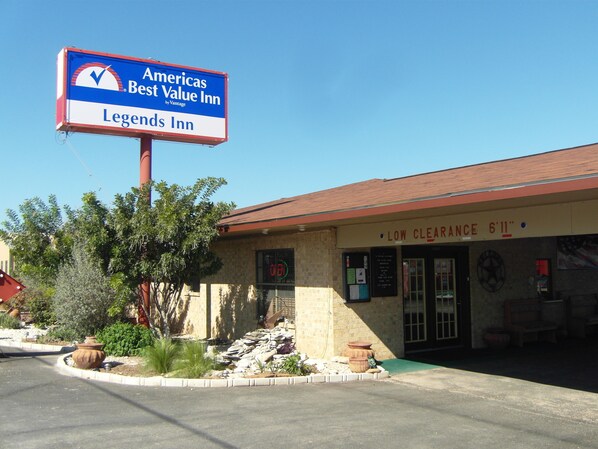 A building with a sign for 'Americas Best Value Inn Legends Inn' and a 'Low Clearance 6'11"' sign.