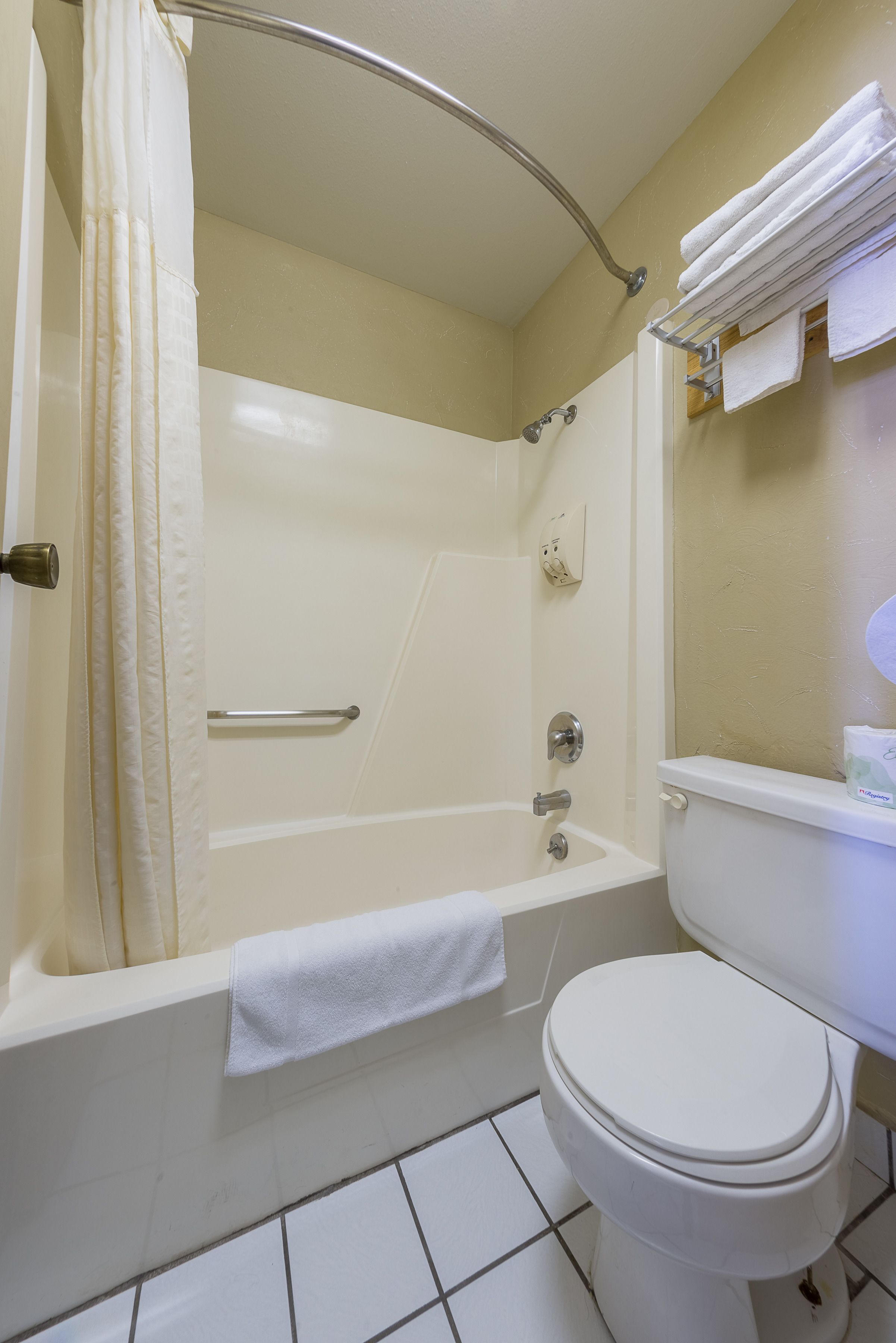 Ein Badezimmer mit Badewanne, Toilette und Handtuchhalter.