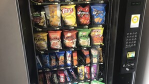 A vending machine stocked with various snacks and beverages.