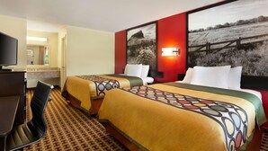 A hotel room with two beds, a desk, and a TV.