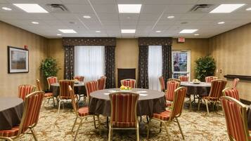 A conference room with round tables, red-striped chairs, and a patterned carpet.