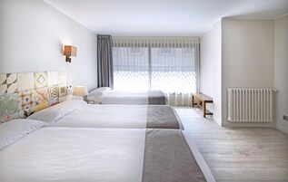 Cubrecamas, espacio para trabajar con laptop y cortinas blackout 