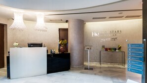 A hotel reception area with a modern design, including a reception desk, a column, and a signboard with room numbers. - Ikonik Ramblas (Barcelona)