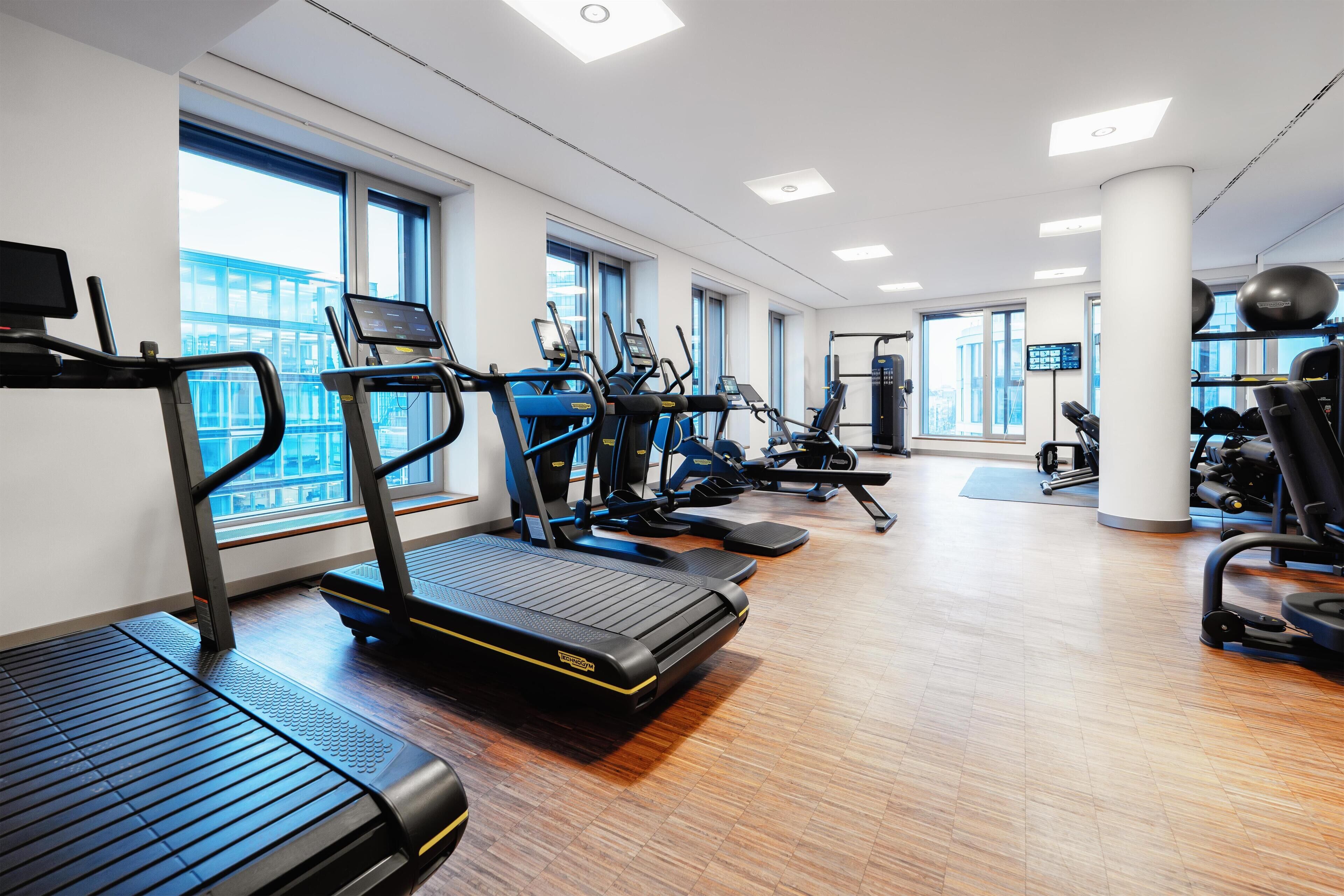 A gym with treadmills, exercise bikes, and weight machines.