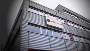 Een hotelgebouw met een gegeerd metalen gevel en een bord waarop staat 