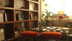 A cozy living room with a bookshelf, a sofa, and a coffee table.