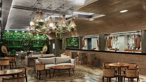 Un intérieur moderne avec un plafond haut, des poutres apparentes et des lustres en osier suspendus.
