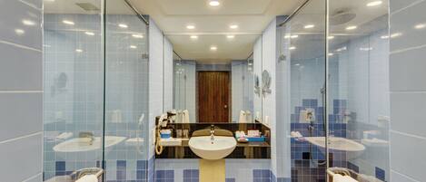 Une salle de bain moderne avec deux lavabos, un grand miroir et une douche à l’italienne.