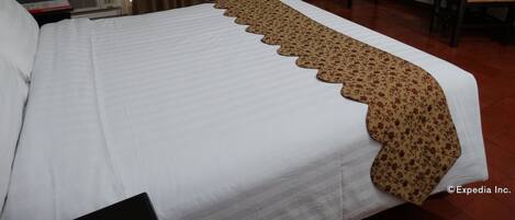 Une chambre d’hôtel avec un grand lit, un bureau, une chaise et un radiateur.