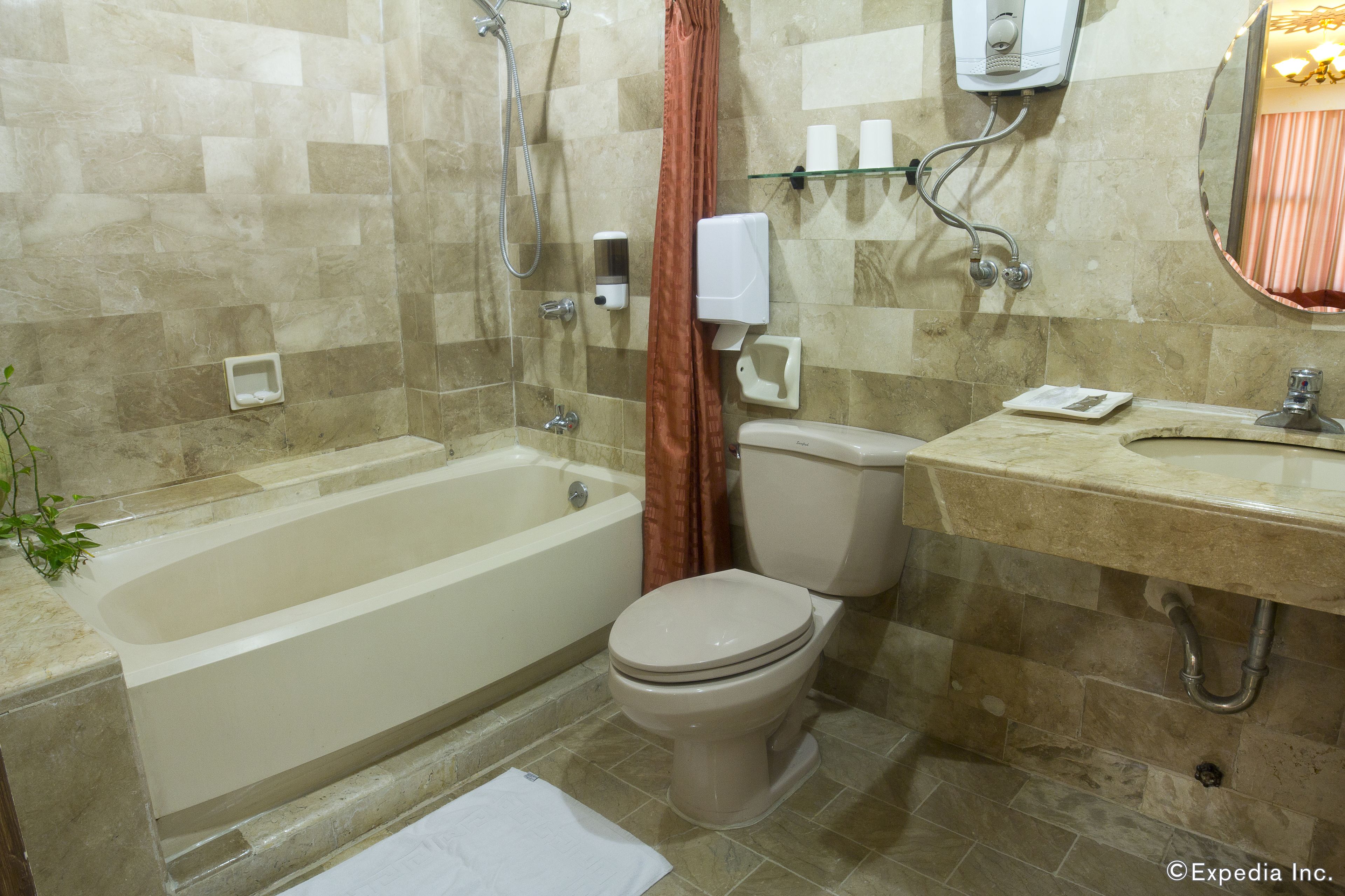 A bathroom with a bathtub, toilet, and sink.