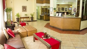 A hotel lobby with a reception desk, seating area, and a bar. - White Knight Hotel Intramuros (Manila)
