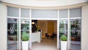 The entrance to Platinum Palace with a reception desk, seating area, and potted plants. - Platinum Apartments Aparthotel (Poznan)
