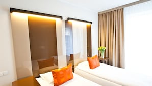 A hotel room with two beds, a nightstand, a mirror, and a window with curtains. - Platinum Apartments Aparthotel (Poznan)