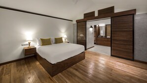 Une chambre à coucher avec un lit en bois, des lampes de chevet, un ventilateur de plafond et un placard à portes coulissantes.