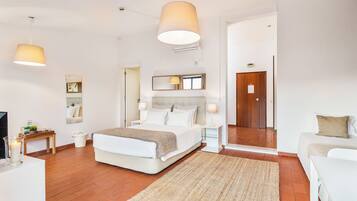 A modern bedroom with a large bed, bedside tables, a mirror, and a TV.