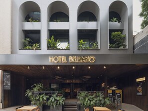 L’entrée d’un hôtel au design moderne, avec une enseigne indiquant « HÔTEL BELIZARDO ».