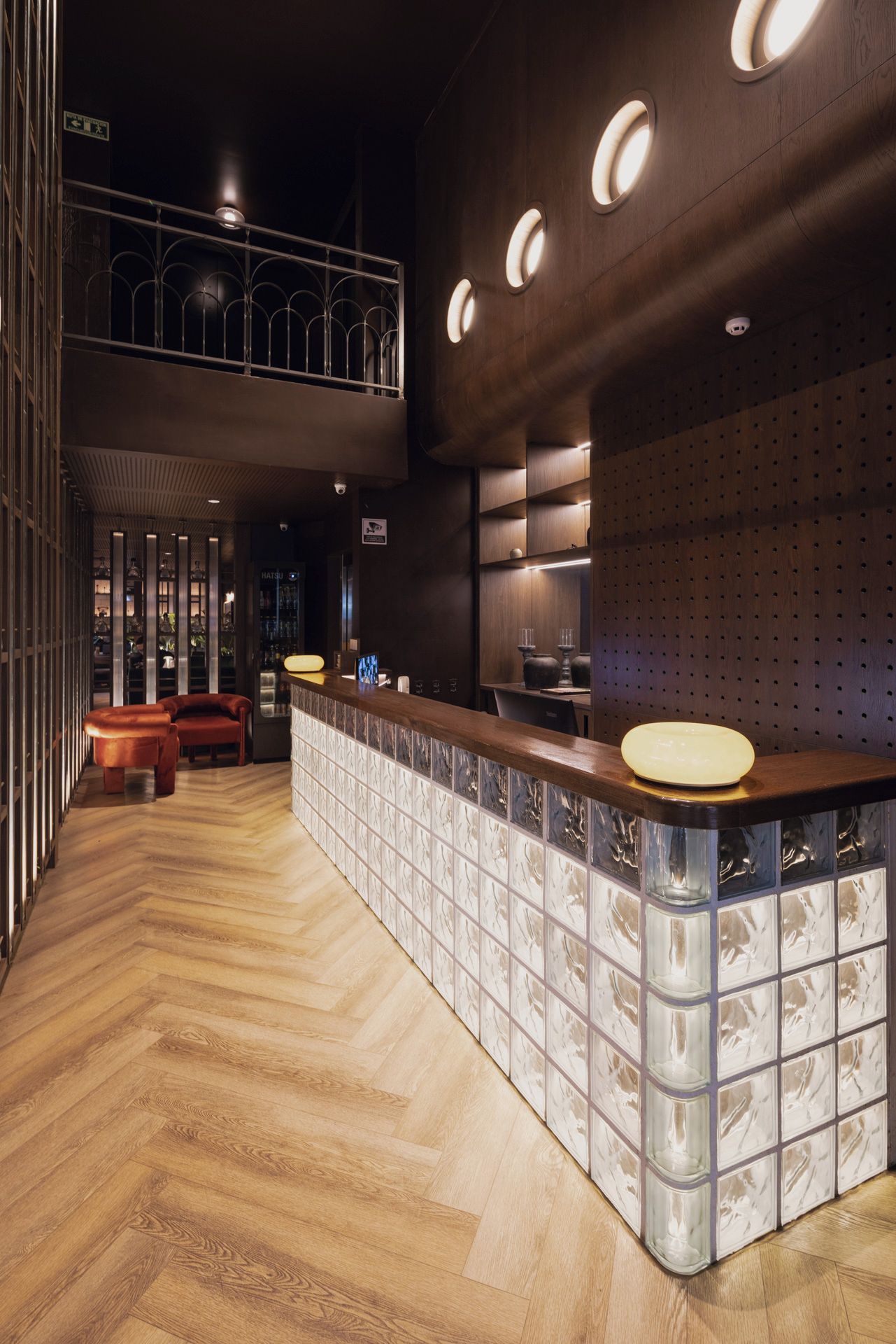 A modern bar area with a wooden counter and seating.