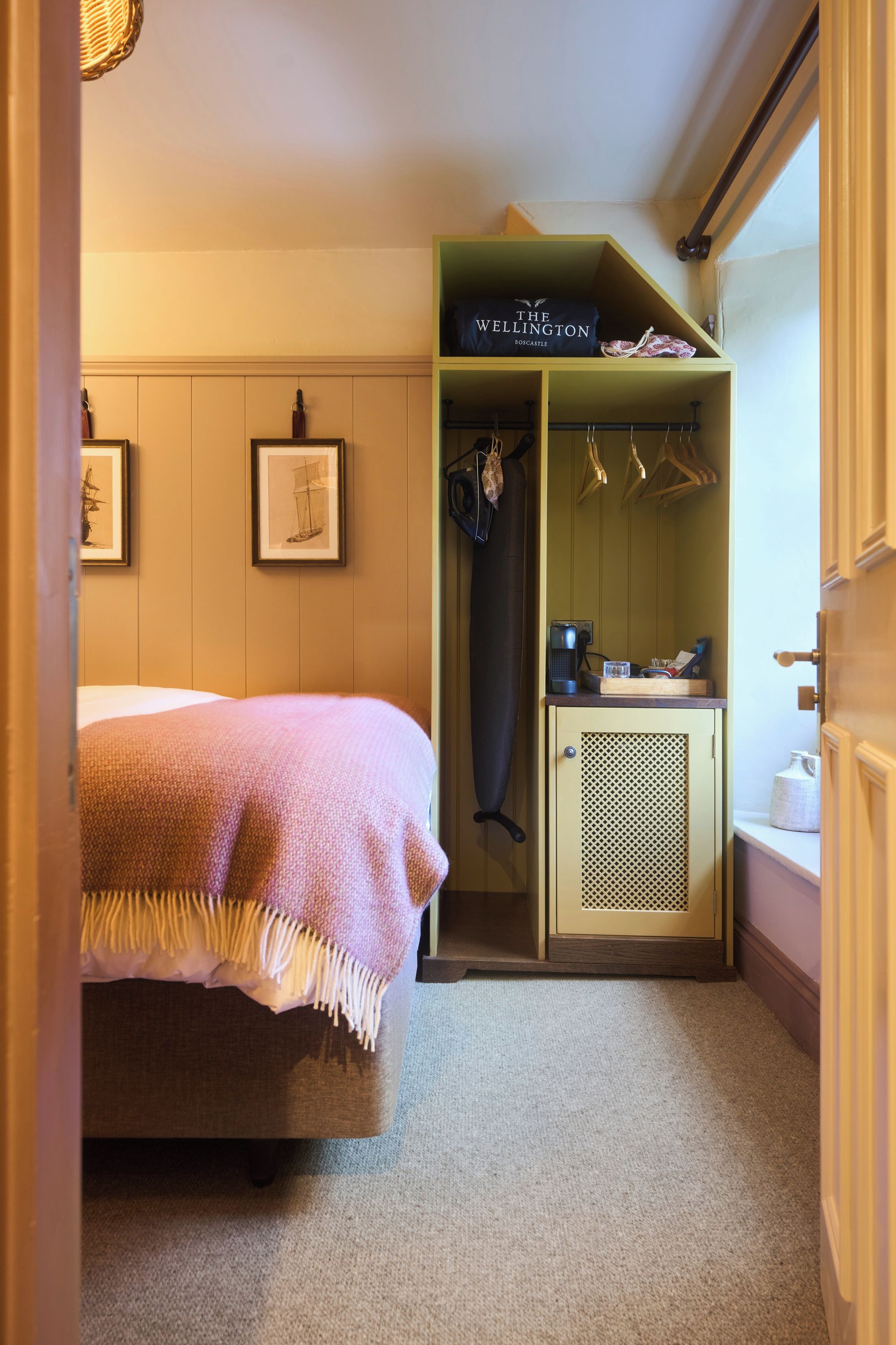 A bedroom with a bed, a wardrobe, and a small kitchenette area.