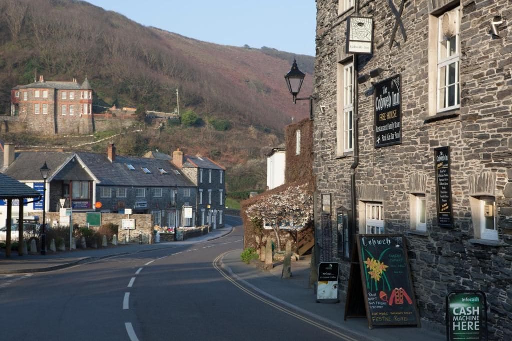 A stone building with a sign for 'The Cobweb Inn' indicating it is a free house with a restaurant and guest room.
