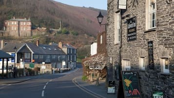 A stone building with a sign for 'The Cobweb Inn' indicating it is a free house with a restaurant and guest room.