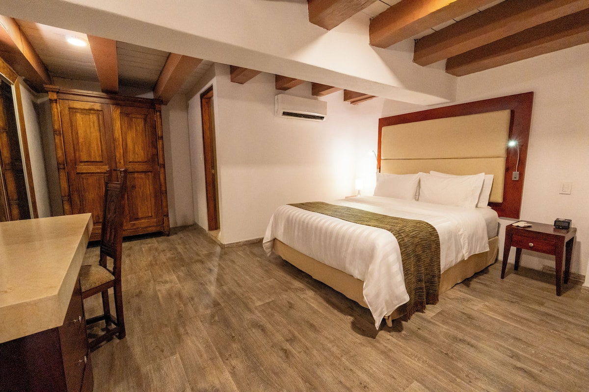 A bedroom with a wooden bed, a bedside table, and a wooden wardrobe.