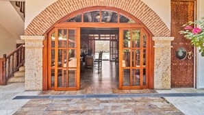 Un ingresso con arco in mattoni e porta in legno con vetrate.