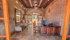 Un interno rustico con parete in mattoni, soffitto in legno e zona pranzo con tavolo e sedie.