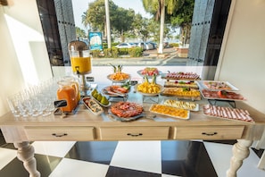 Ein reichhaltiges Buffet mit verschiedenen Speisen und einem Saftspender.