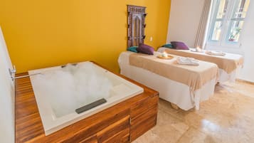 Relax in a spacious room with a bathtub, two comfortable beds, and a bright window.