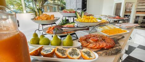 Buffet com diversas frutas, legumes e carnes.