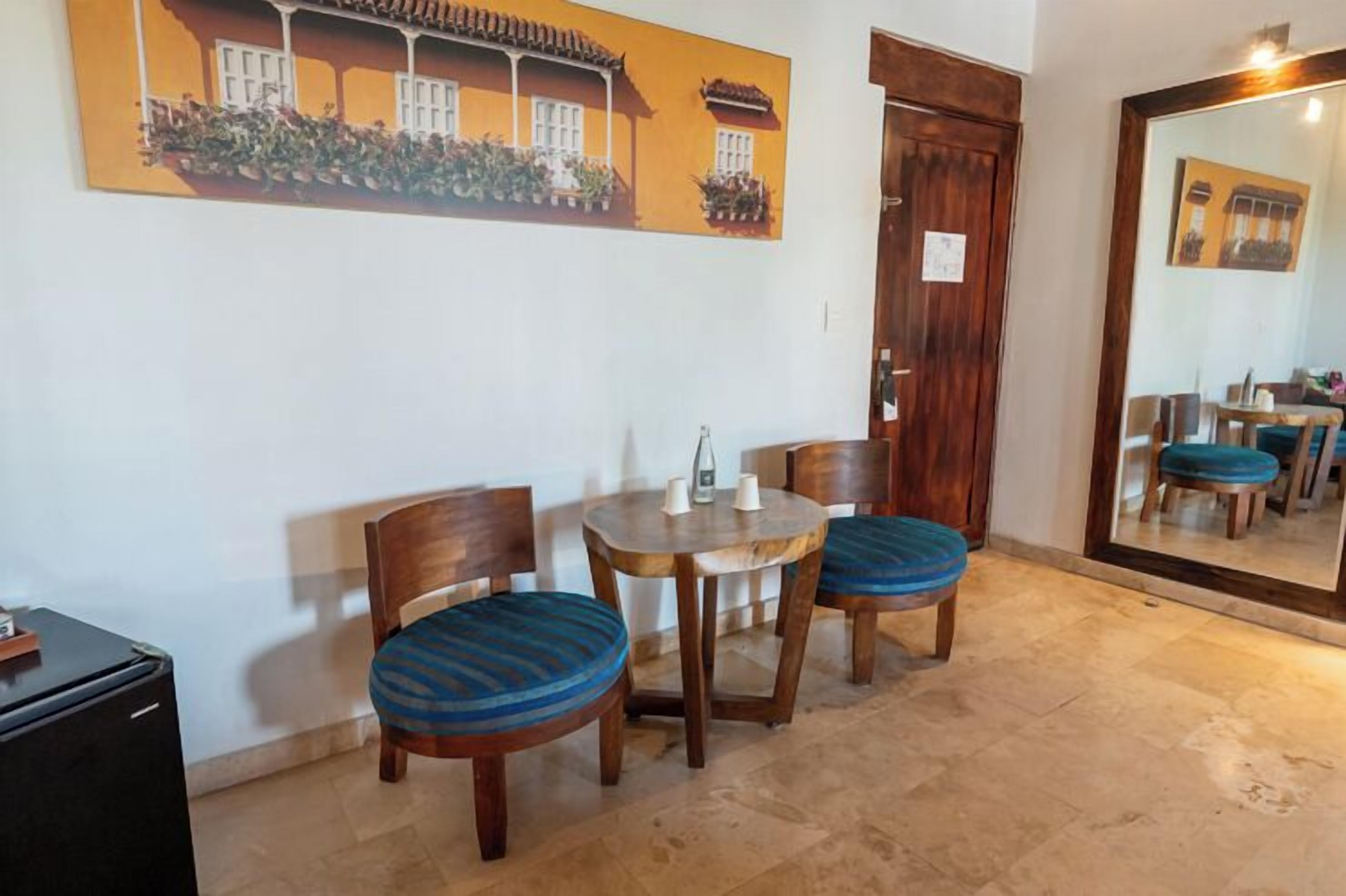 Un comedor con una mesa redonda, dos sillas y una puerta de madera.