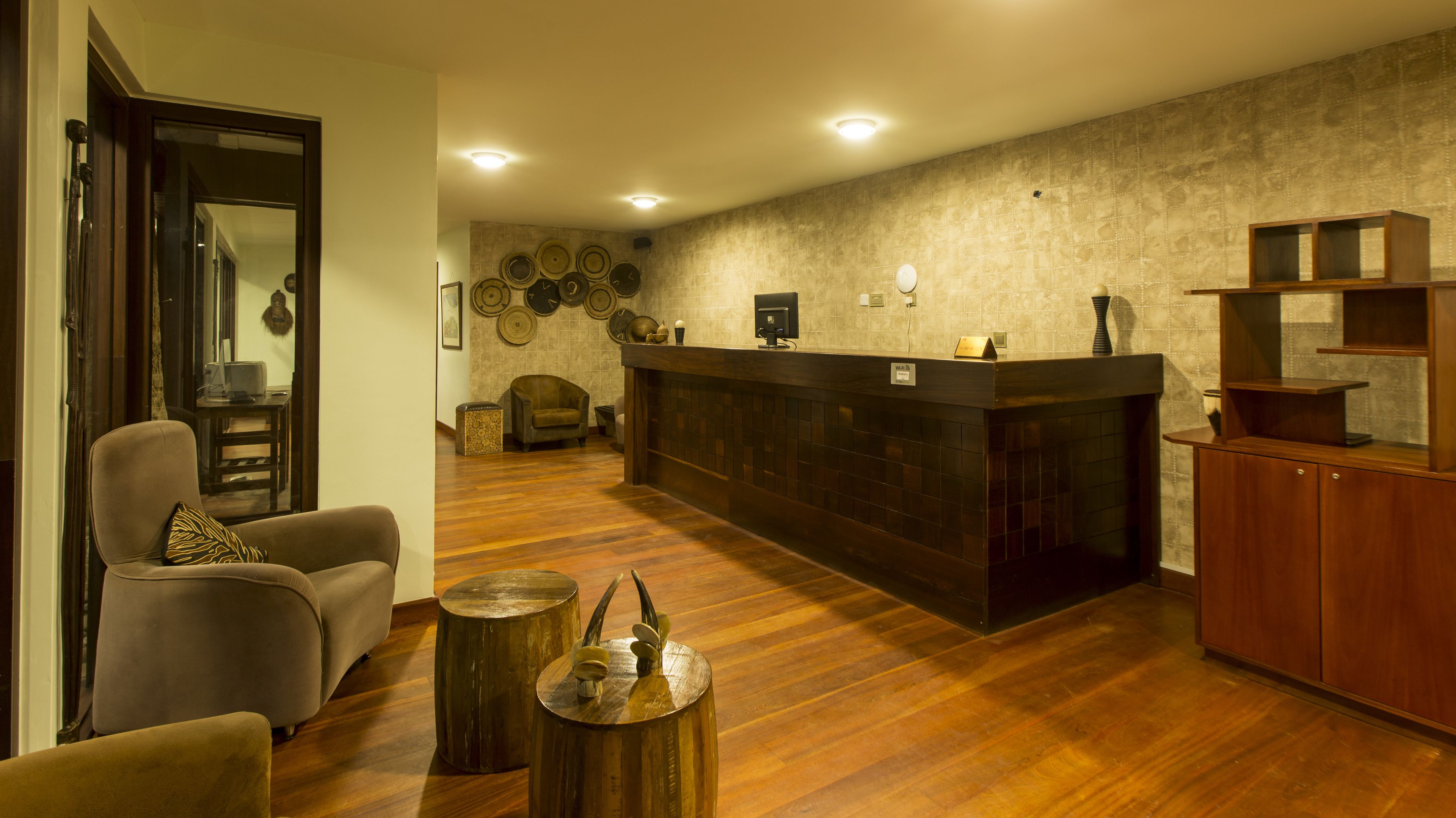 A modern lobby with a reception desk, seating area, and decorative wall art.