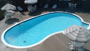 Une piscine avec des chaises longues et des parasols.