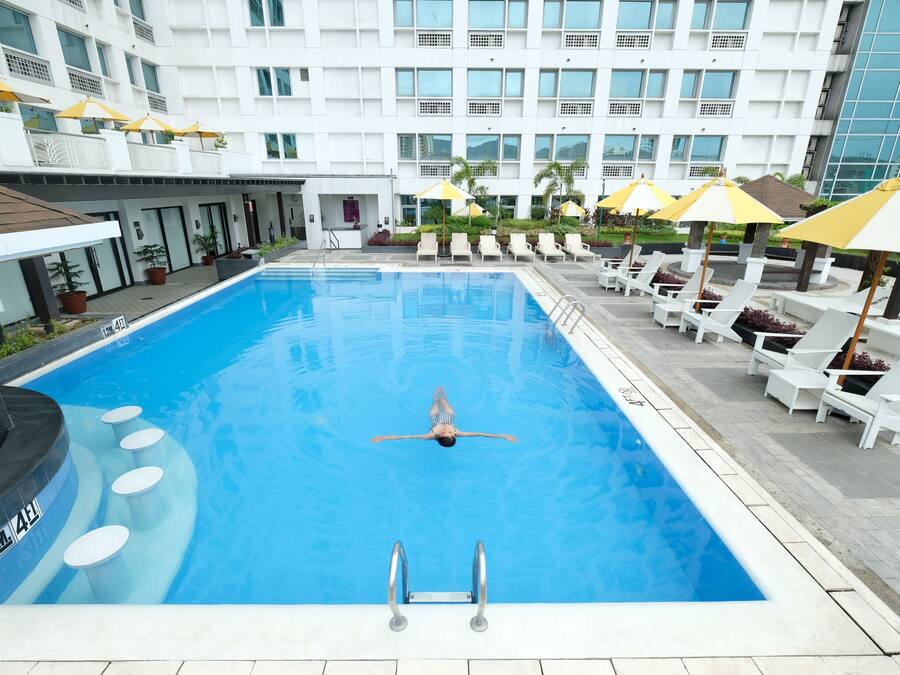 Een buitenzwembad, ligstoelen bij het zwembad